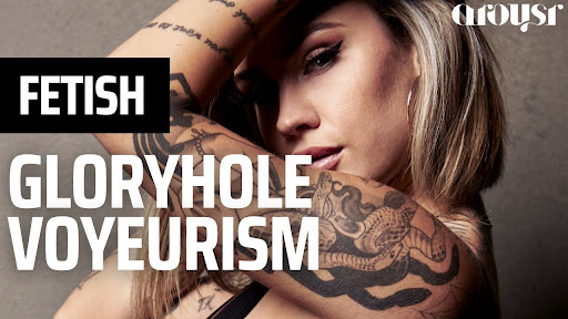Heavily Tattooed Blonde Alternative Model poses wearing black eyeliner and plump lips