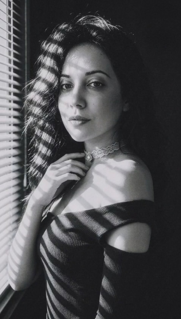 Soft shadows dance across bare skin in a intimate monochrome moment A captivating gaze that pulls you in with quiet passionate intensity