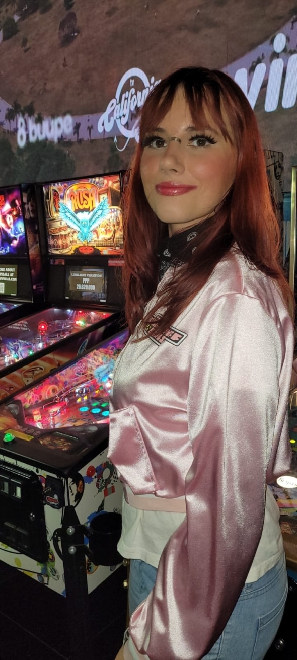 Me playing games at a hotel with pink jaquet